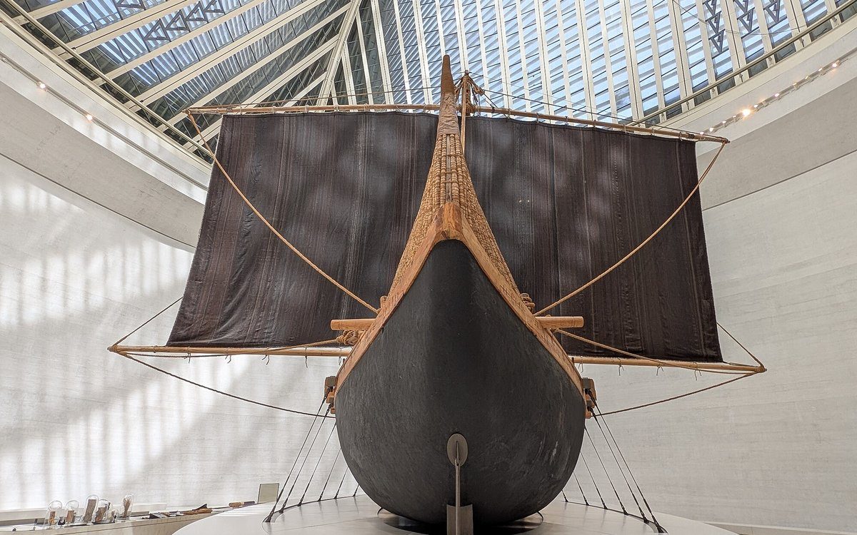 Una barca de Magan de la Edad del Bronce reconstruida, con su vela oscura desplegada, se alza bajo la cubierta acristalada del Zayed National Museum.