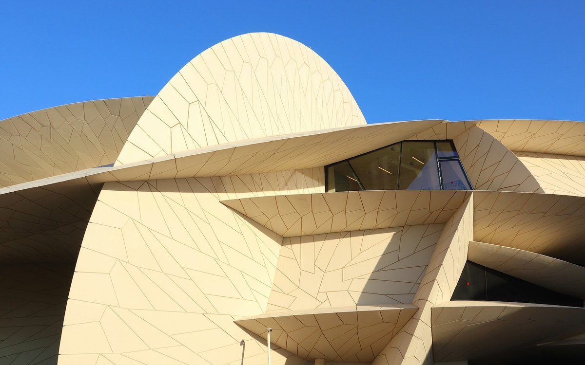 Los discos entrelazados en forma de rosa del desierto del Museo Nacional de Catar se alzan contra un cielo azul despejado de Doha.