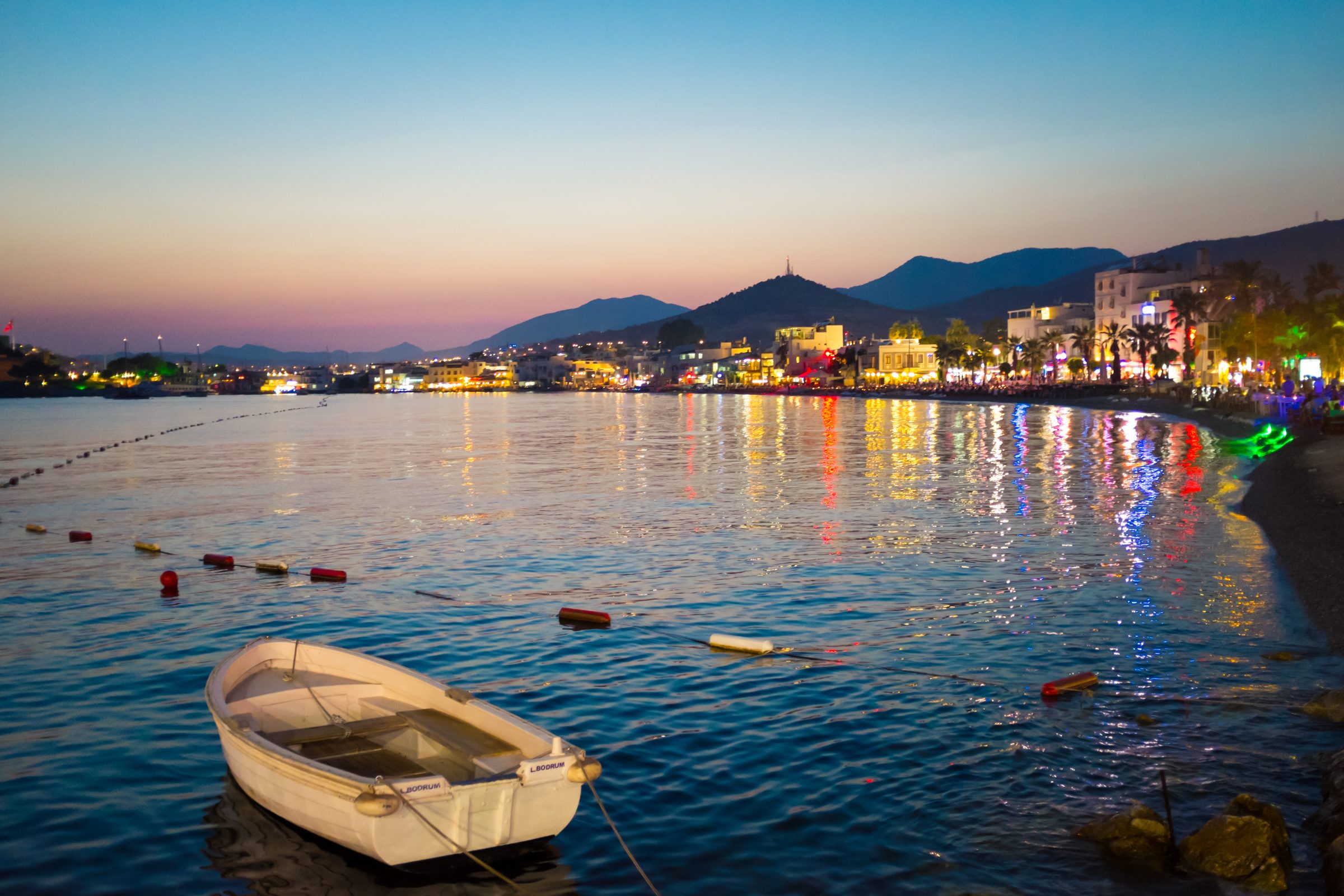La bahía de Bodrum al anochecer, con las luces del puerto reflejadas en el agua