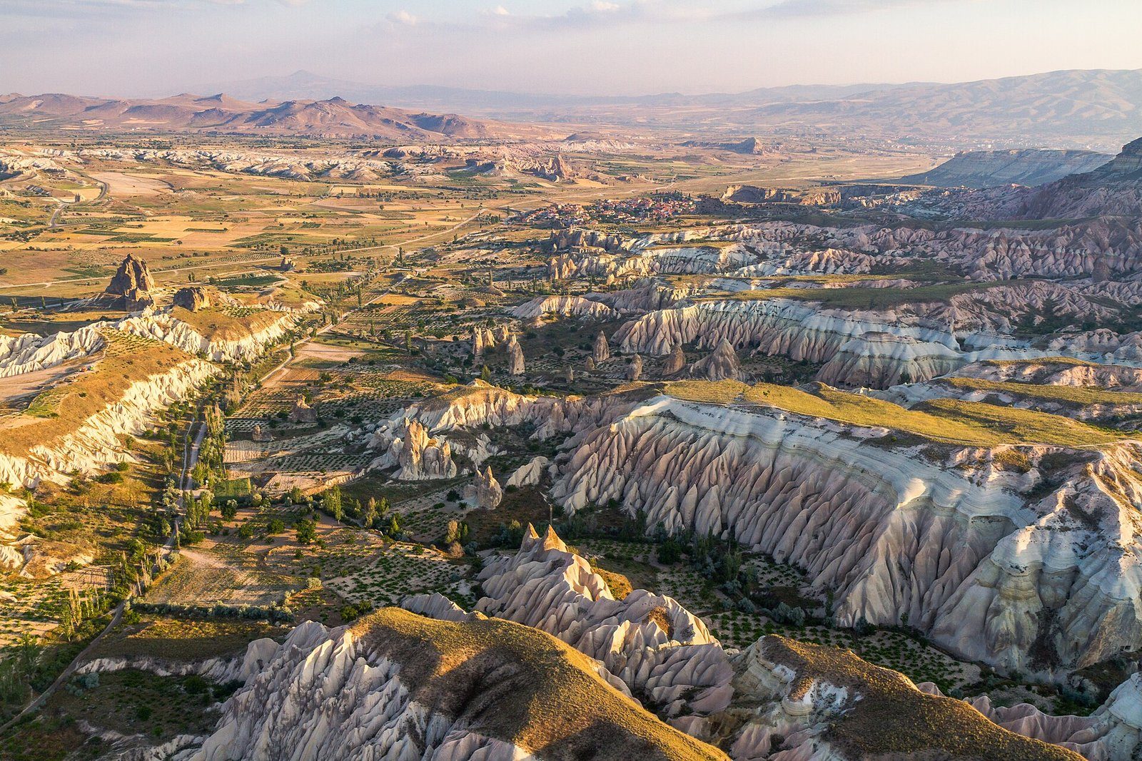 Los valles y crestas rocosas de Capadocia cerca de Göreme con la cálida luz de primera hora, vistos desde el aire
