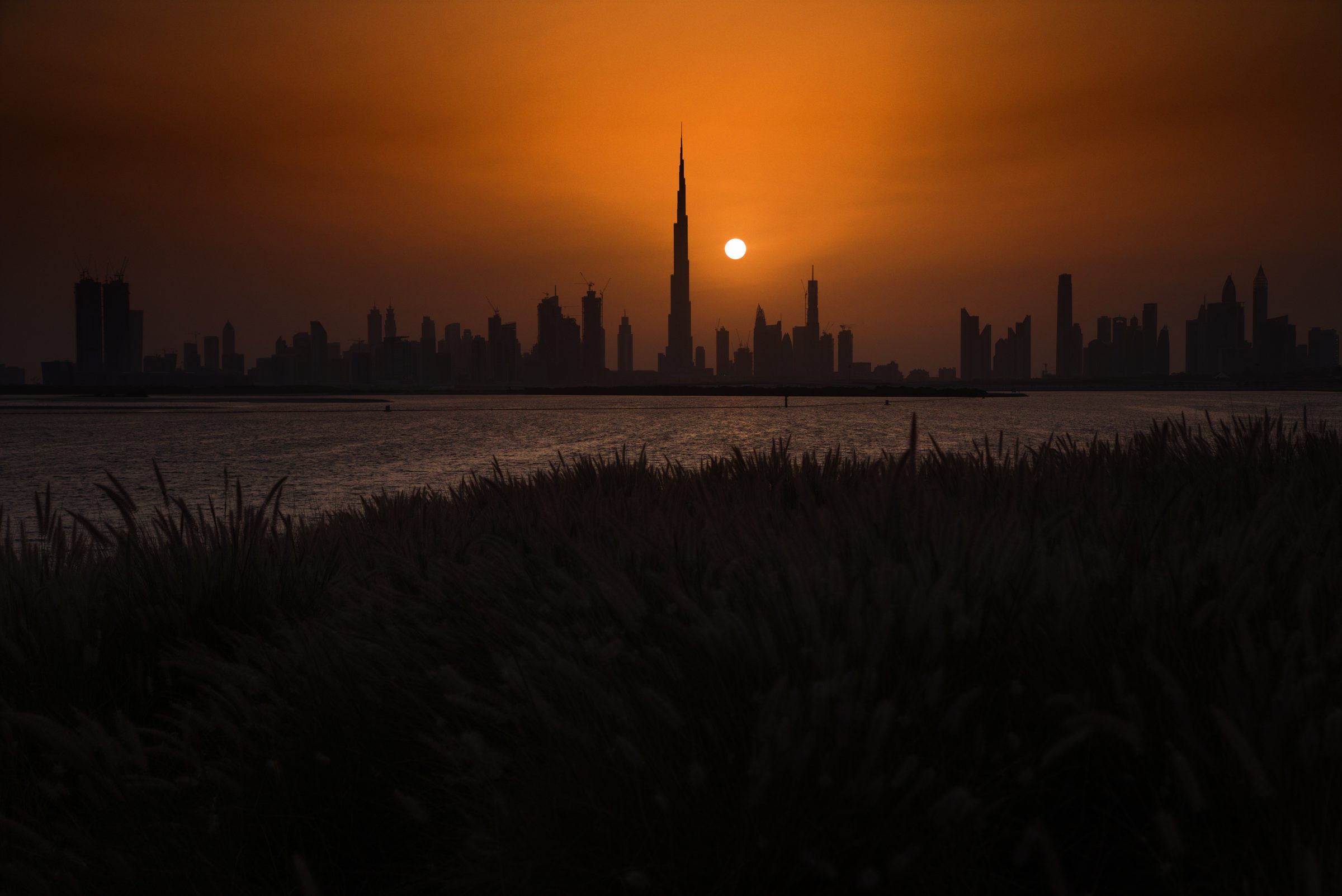 El perfil urbano de Dubái y el Burj Khalifa, recortados en silueta contra el atardecer