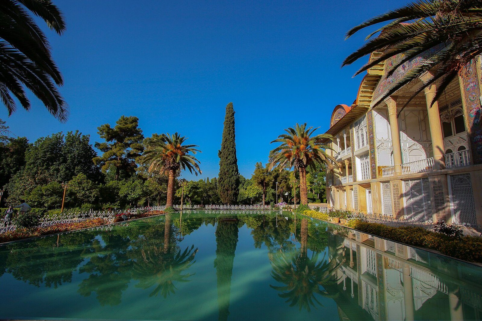 El pabellón Qavam del Jardín de Eram en Shiraz reflejado en su largo estanque entre palmeras y cipreses