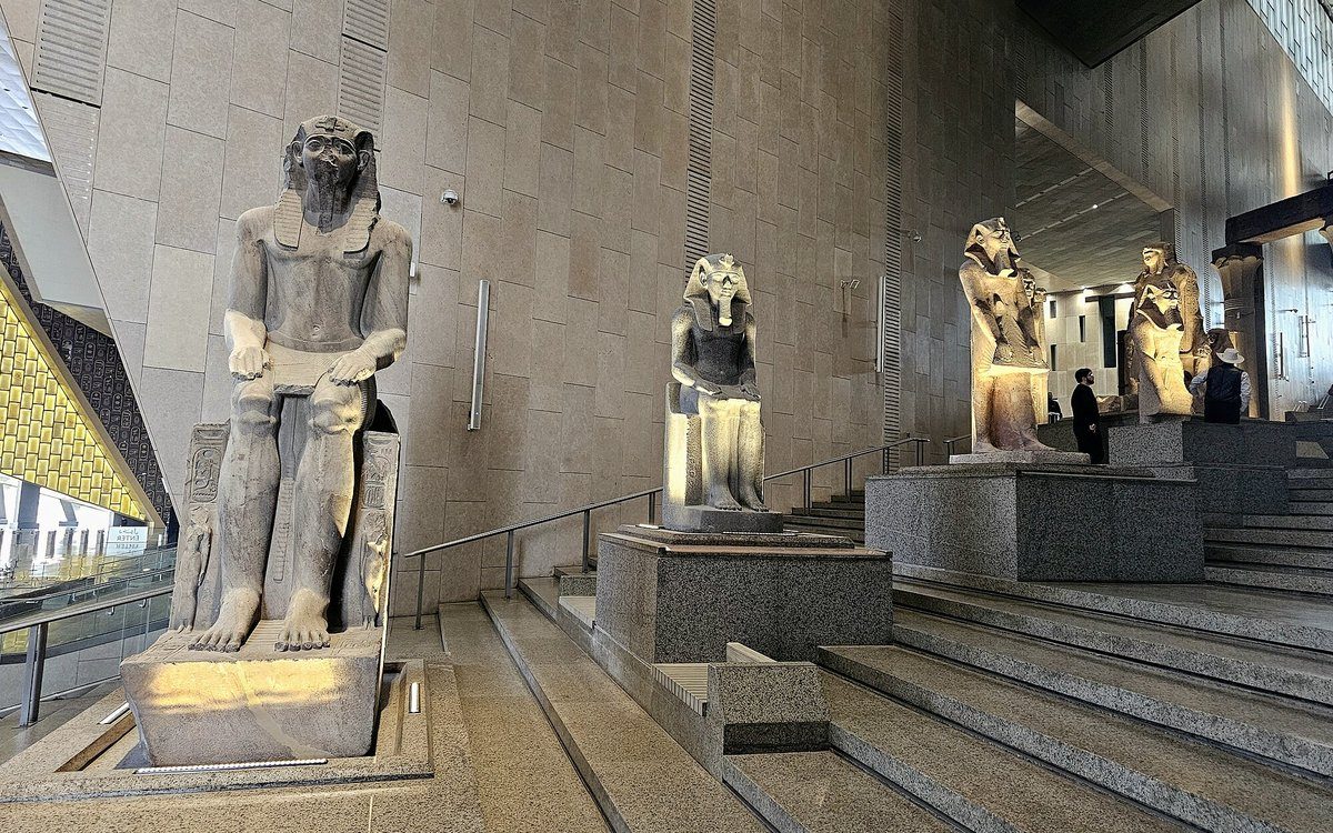 Colosales estatuas faraónicas flanquean la Gran Escalera del Gran Museo Egipcio en Guiza.