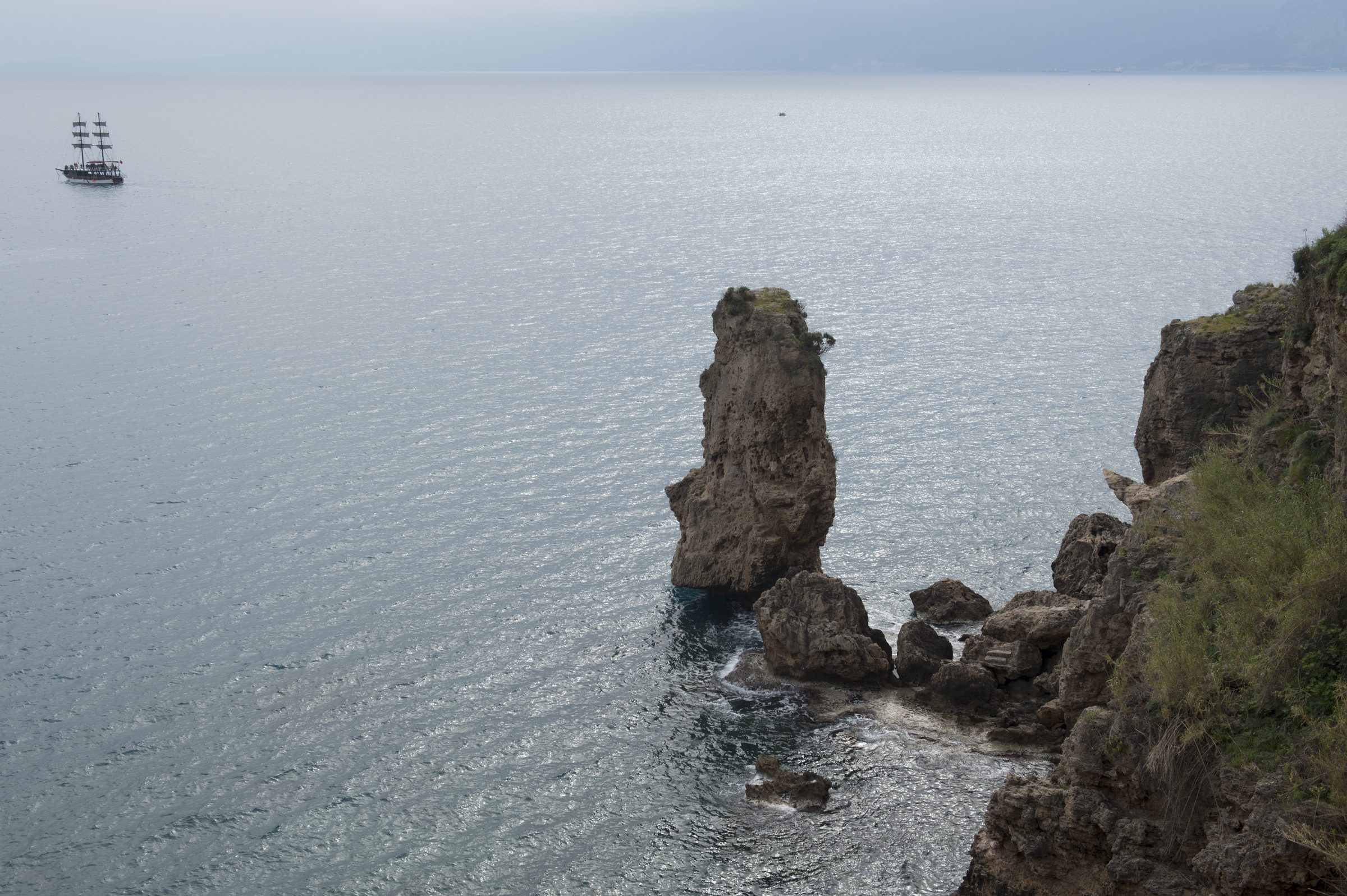 Un farallón solitario y un velero frente a los acantilados de Antalya, en la Riviera turca
