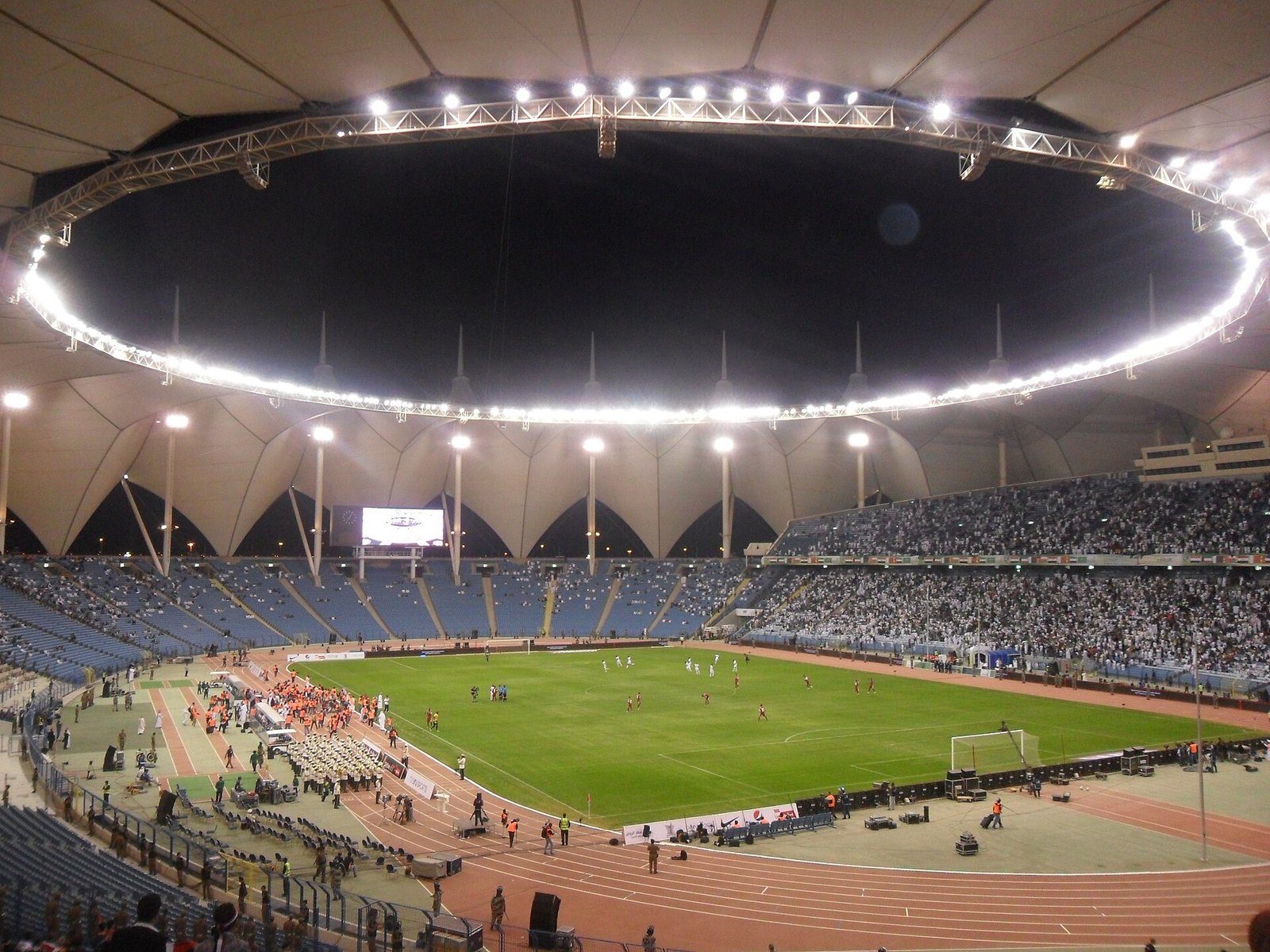 El Estadio Internacional Rey Fahd en Riad, con su cubierta de lona rodeada de focos en una noche de partido.