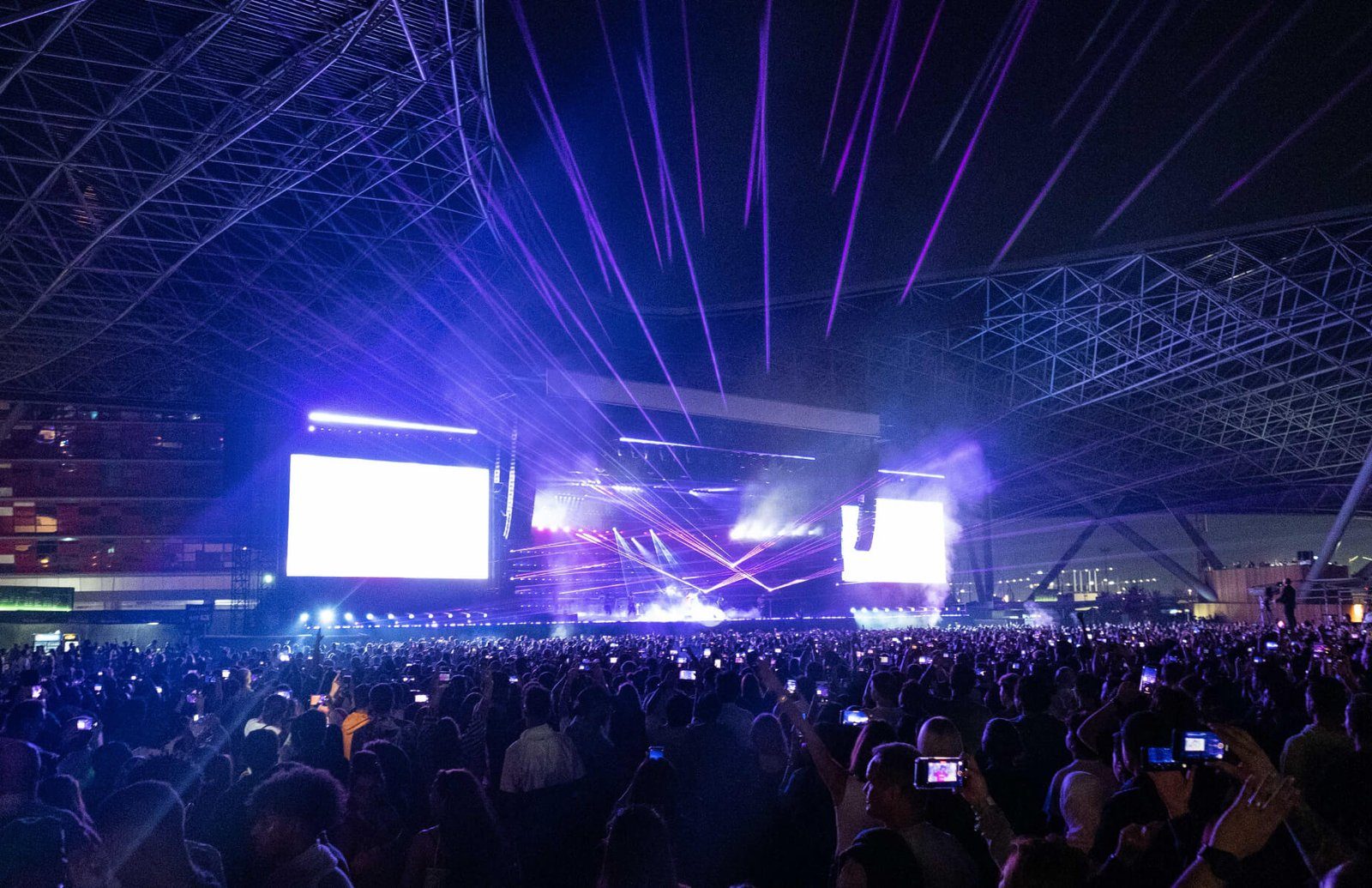 Rayos láser y pantallas del escenario iluminan al público de un concierto en Etihad Park, el recinto al aire libre de la isla de Yas, Abu Dabi.