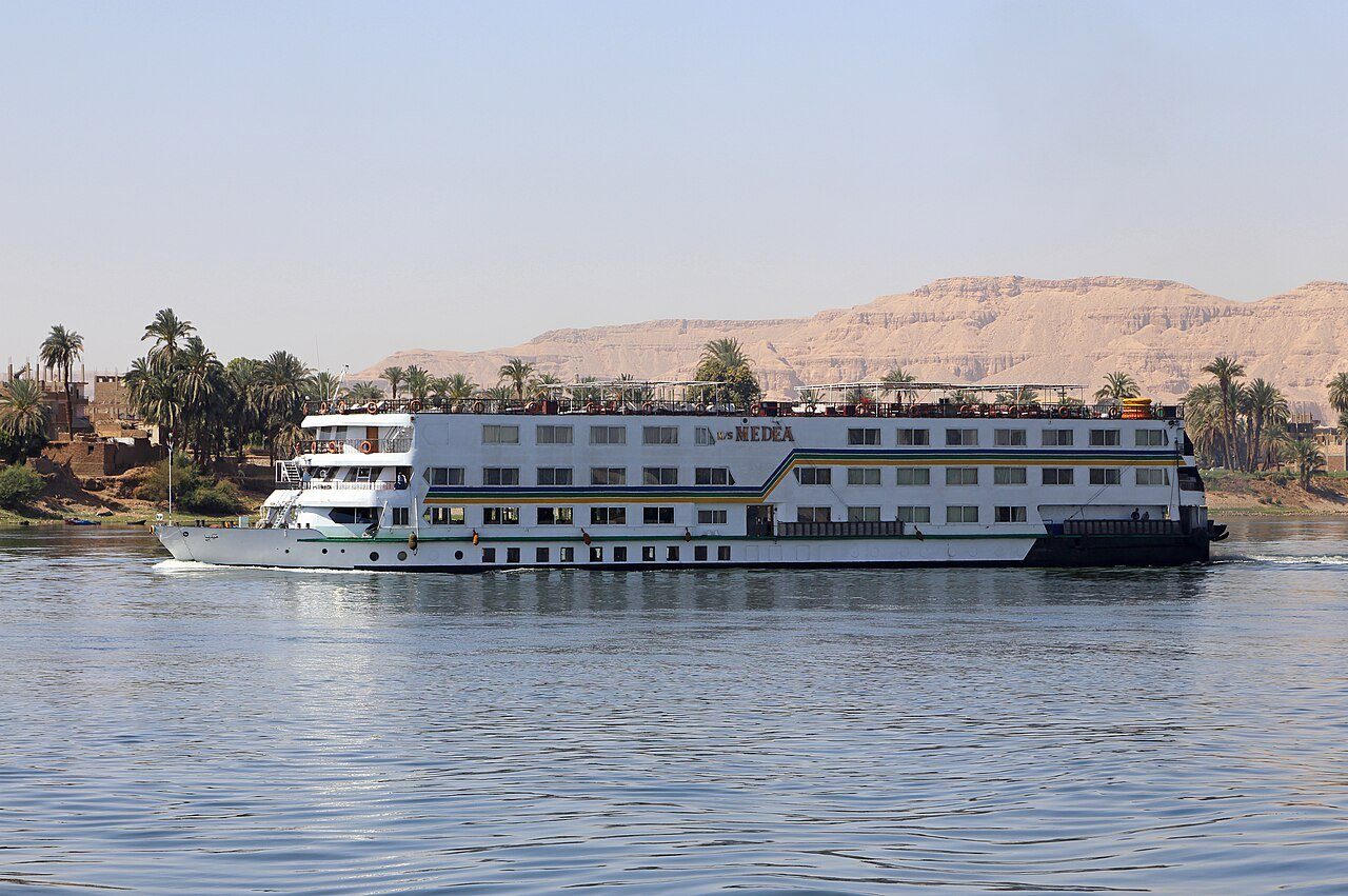 Un crucero por el Nilo deslizándose entre palmeras y las colinas tebanas cerca de Luxor.