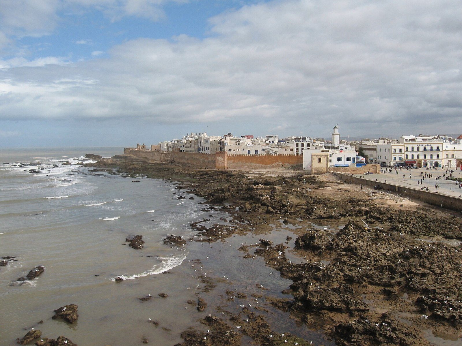 La medina encalada y las murallas marítimas de Esauira se alzan tras la rocosa costa atlántica.