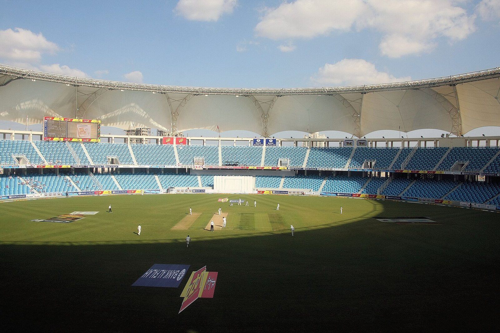 El campo y la curvada cubierta blanca del Dubai International Cricket Stadium en Dubai Sports City.