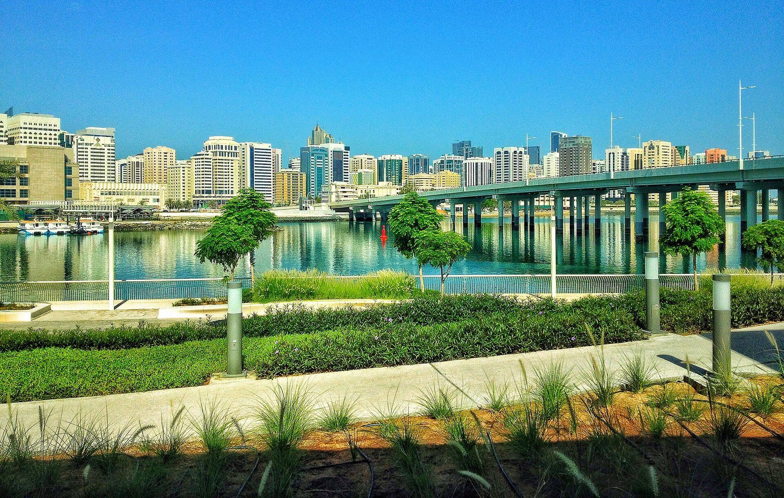 El paseo marítimo ajardinado de la isla Al Maryah, centro financiero y de empresas emergentes de Abu Dabi, con vistas a la ciudad al otro lado del canal.