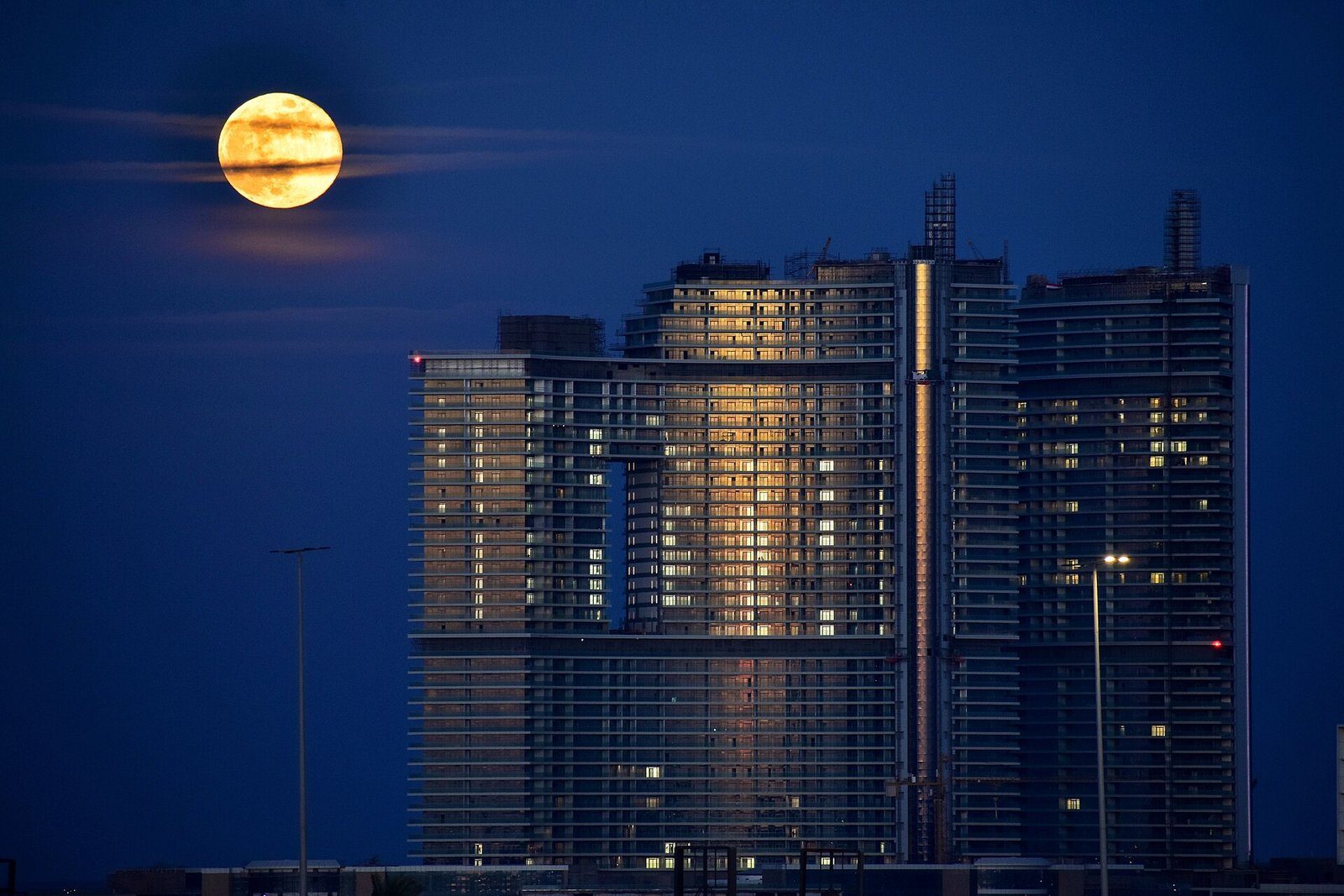 Una luna llena se eleva junto a las torres de cristal de New Alamein, en la Costa Norte de Egipto, durante la hora azul.