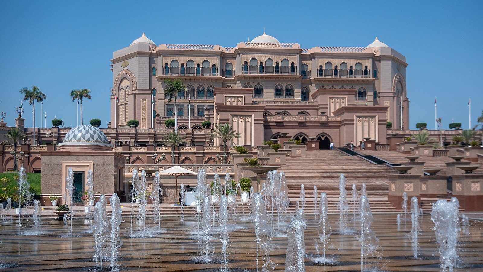 Fuentes danzantes en la explanada del Emirates Palace, con su fachada de tonos rosados y sus cúpulas recortadas contra el cielo despejado de Abu Dabi
