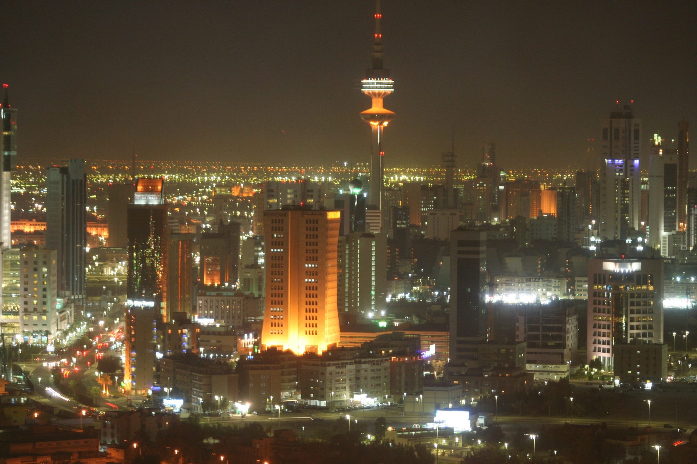 La ciudad de Kuwait resplandece de noche bajo la Torre de la Liberación