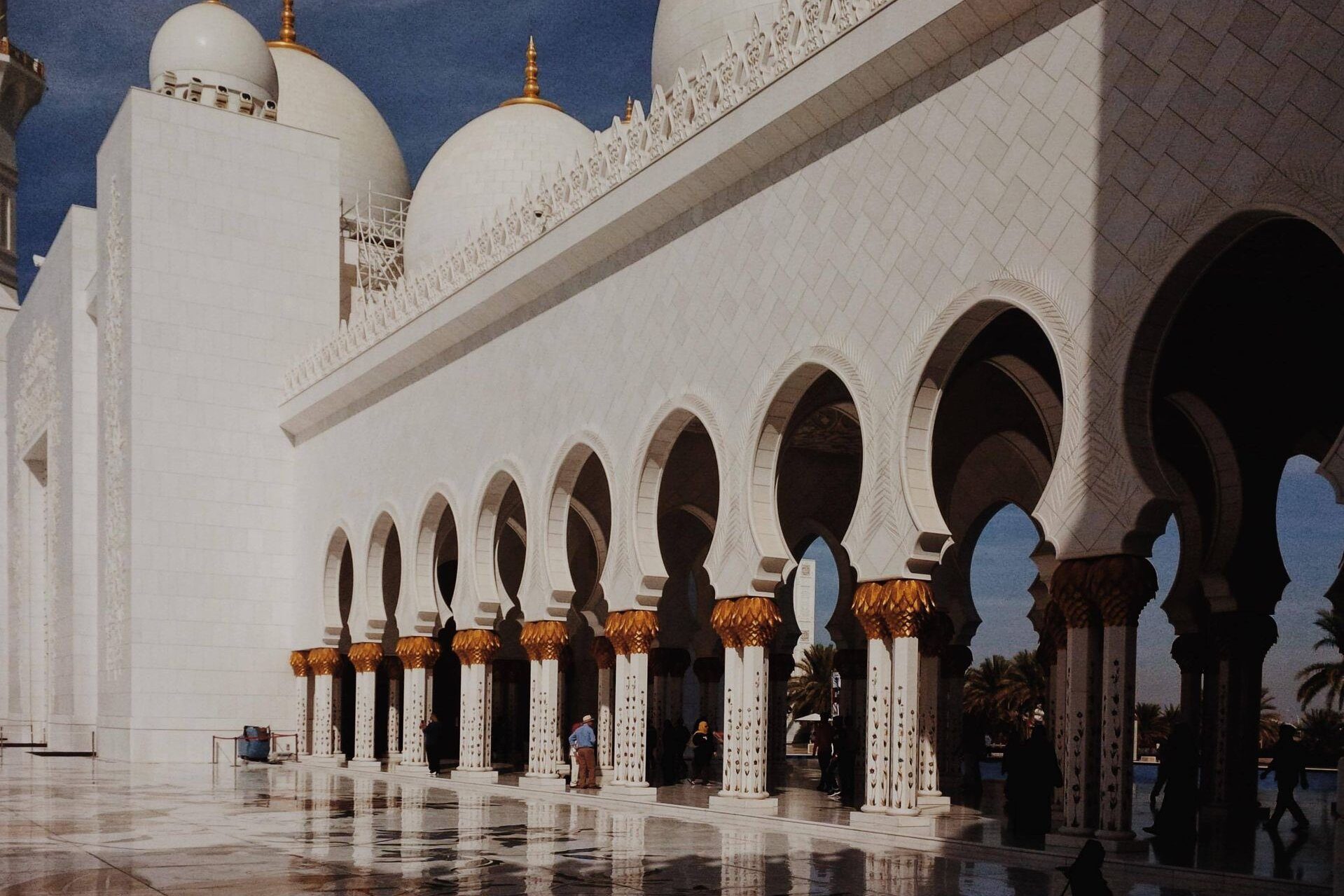 Arcos de mármol blanco y columnas doradas en forma de palmera en la Gran Mezquita Sheikh Zayed, Abu Dabi