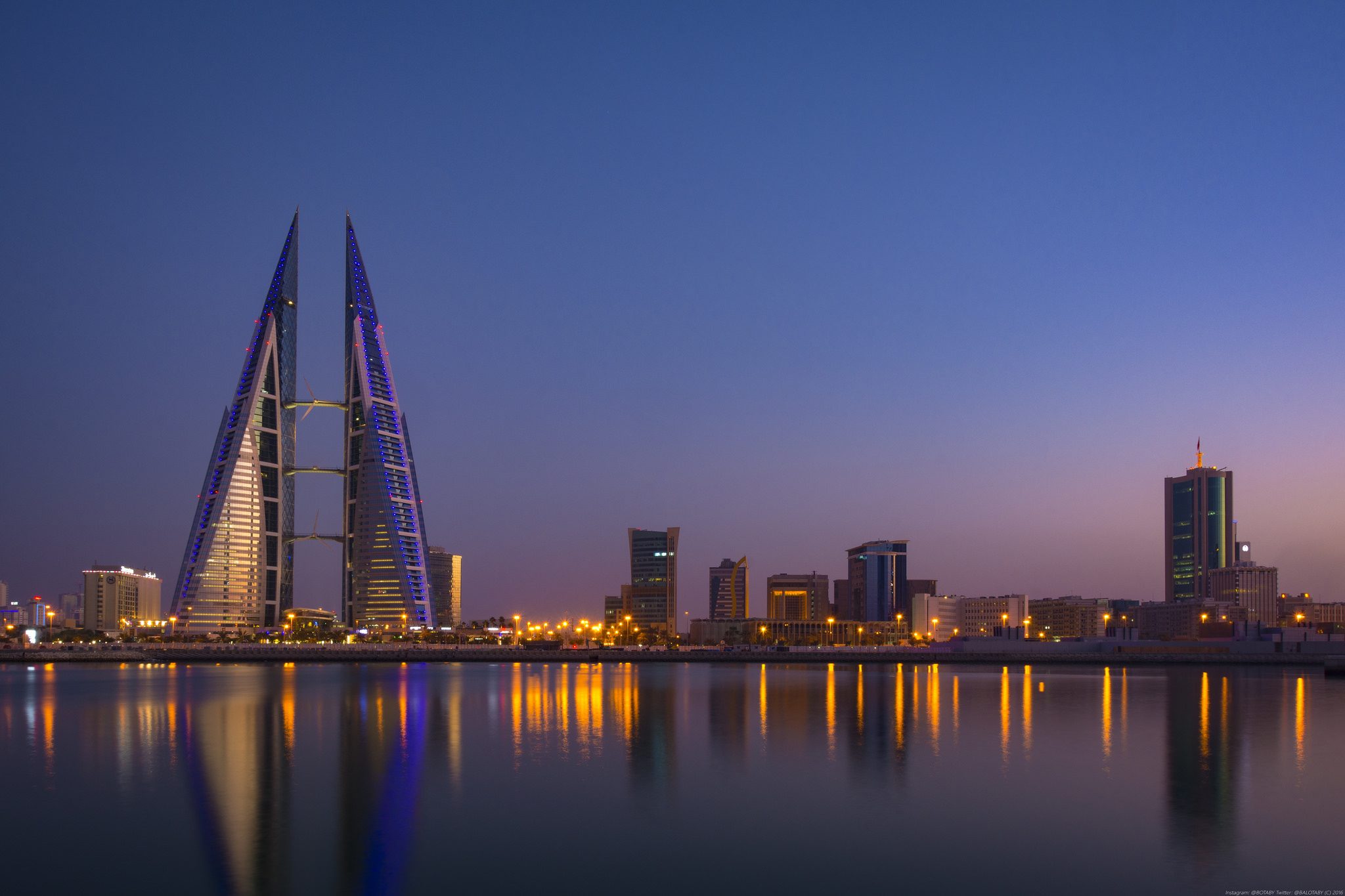 El Bahrain World Trade Center reflejado en el agua al anochecer