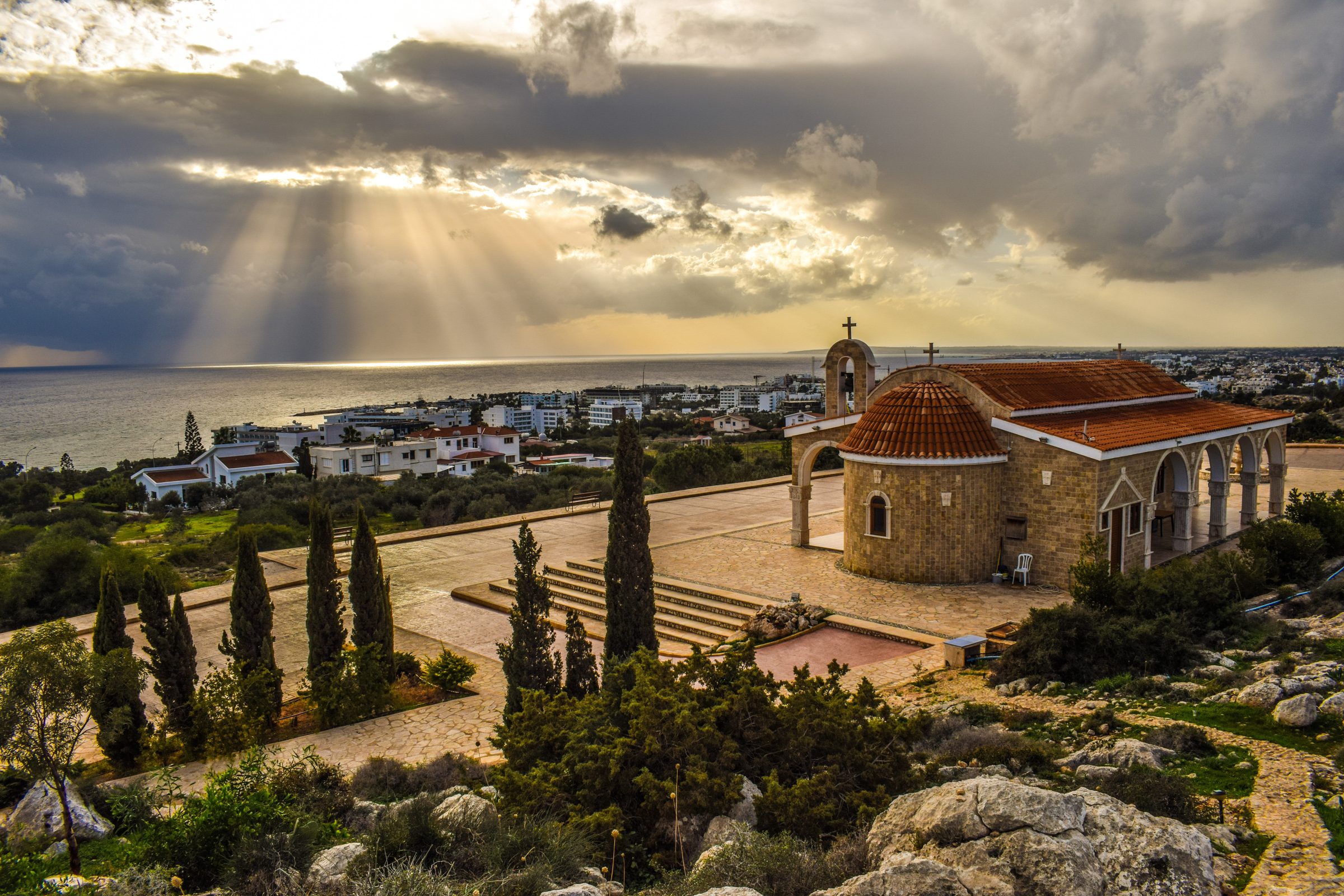 La luz se abre paso entre las nubes sobre la capilla de Agios Epiphanios y la costa de Ayia Napa, Chipre