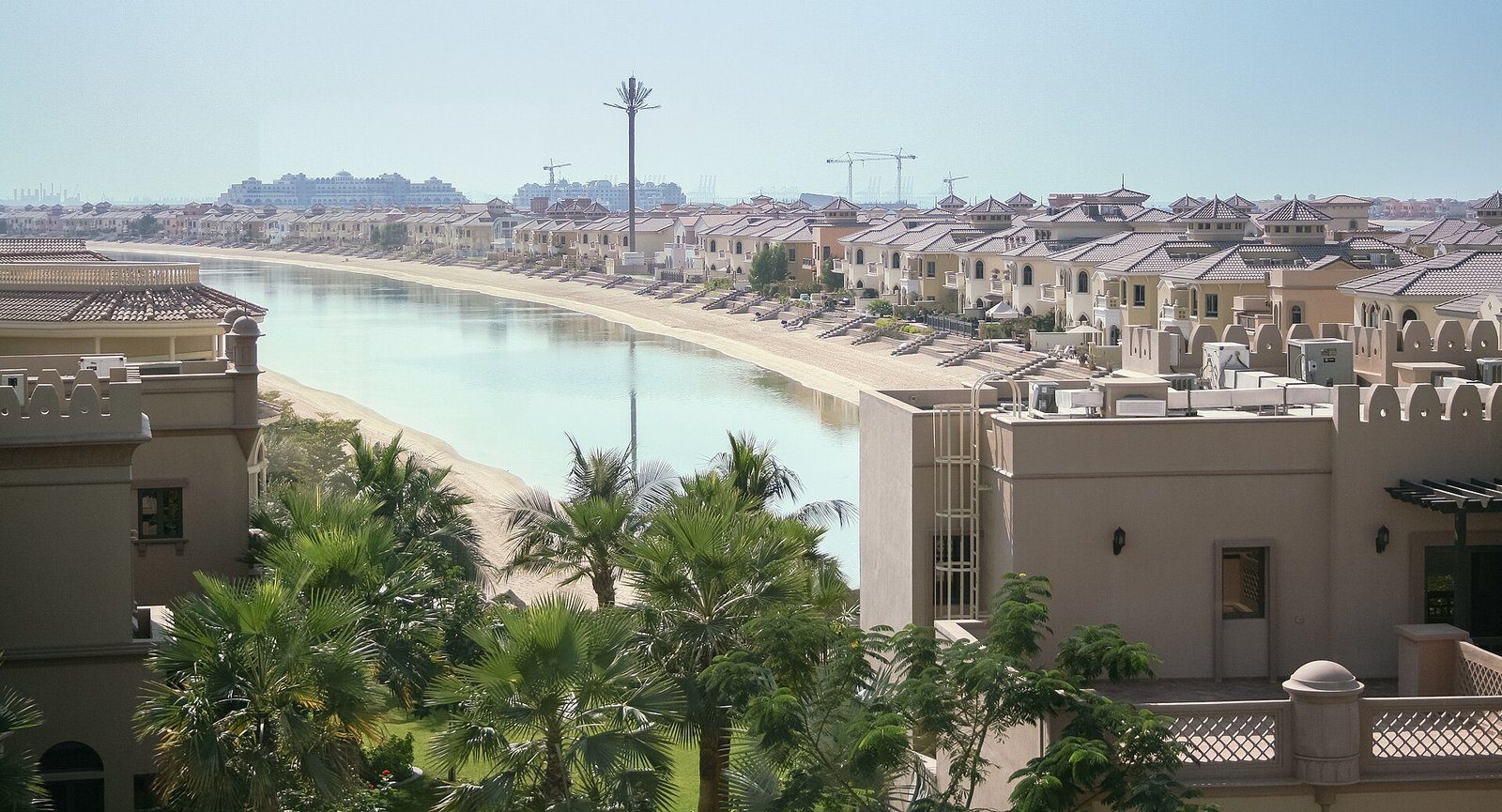 Jardines de palmeras y una larga piscina que serpentea entre las villas color arena del resort Qasr Al Sarab en el desierto de Liwa, Abu Dabi.