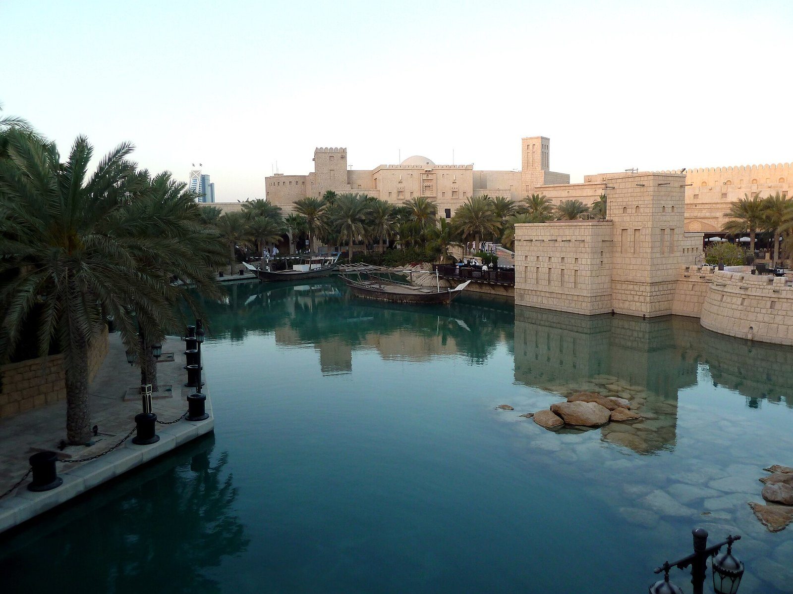 Los canales turquesas y las torres color arena del Souk Madinat Jumeirah, Dubái, enmarcados por palmeras