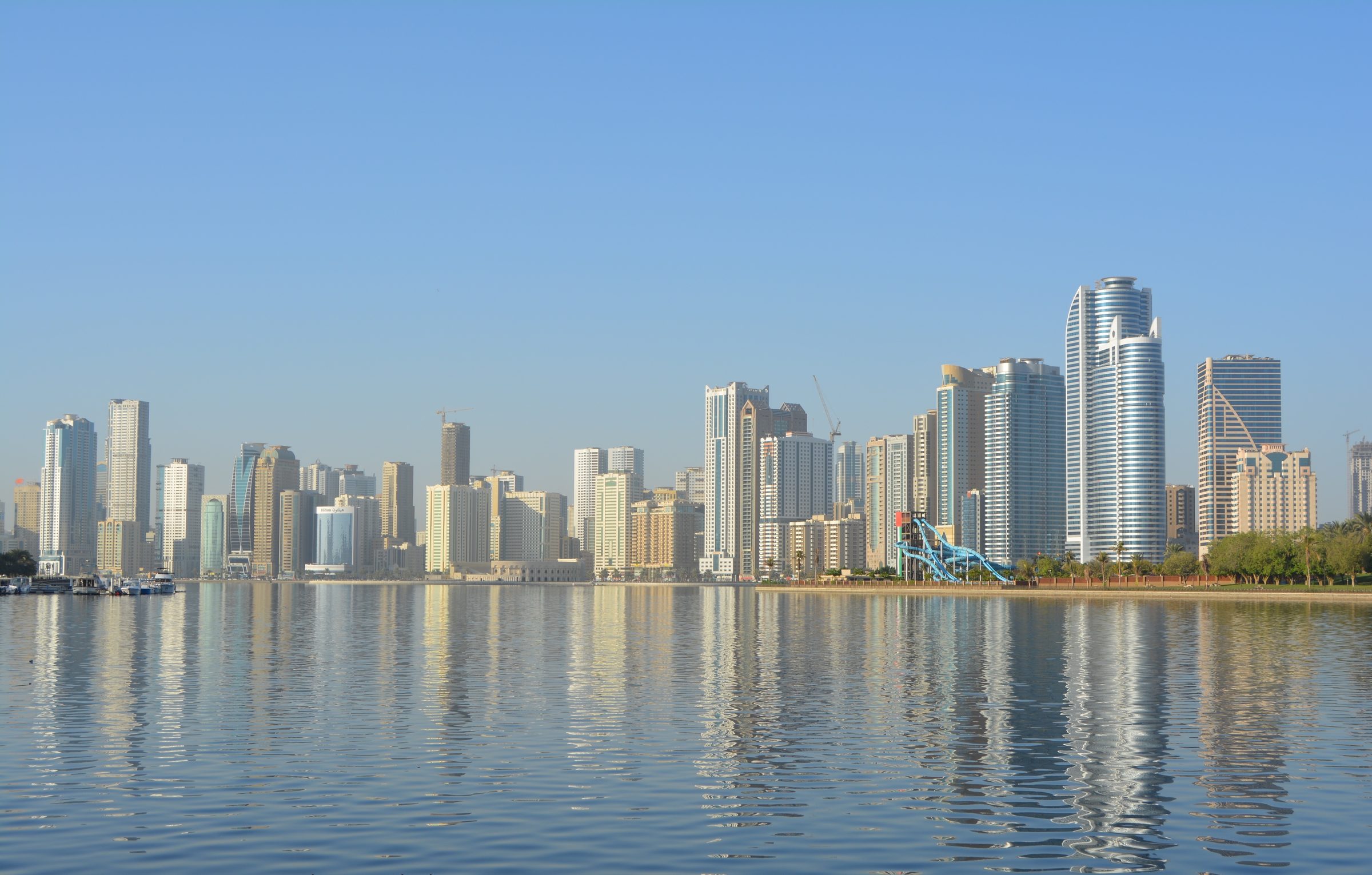 El perfil urbano de Sharjah reflejado en aguas tranquilas