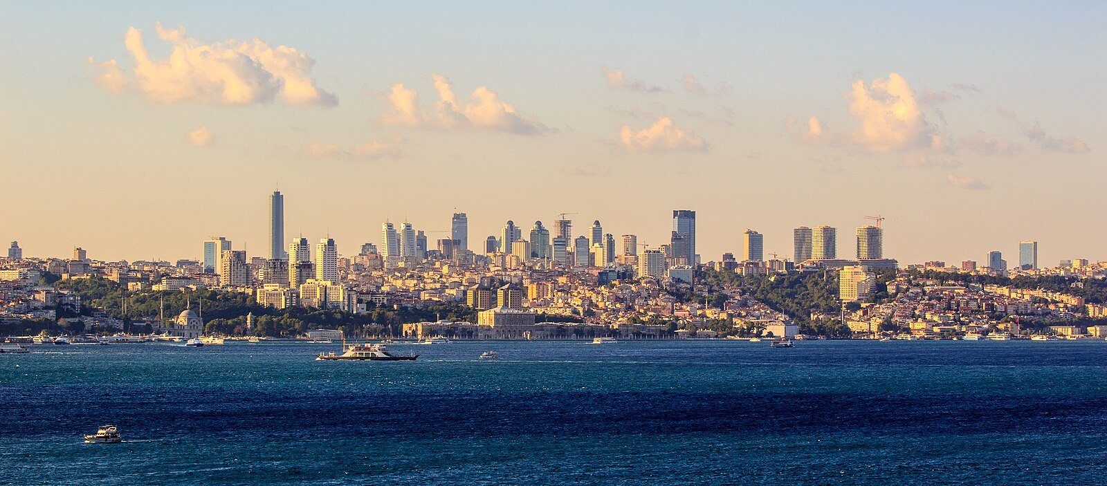 El moderno perfil urbano de Estambul sobre el Bósforo al atardecer, con transbordadores surcando el agua.