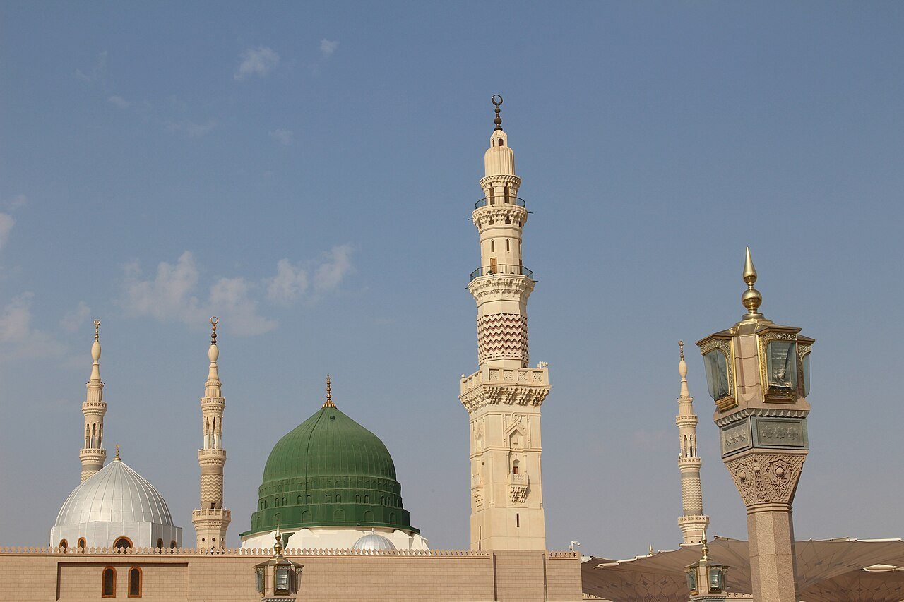 La Cúpula Verde y los minaretes blancos de la Mezquita del Profeta en Medina ante un suave cielo azul.