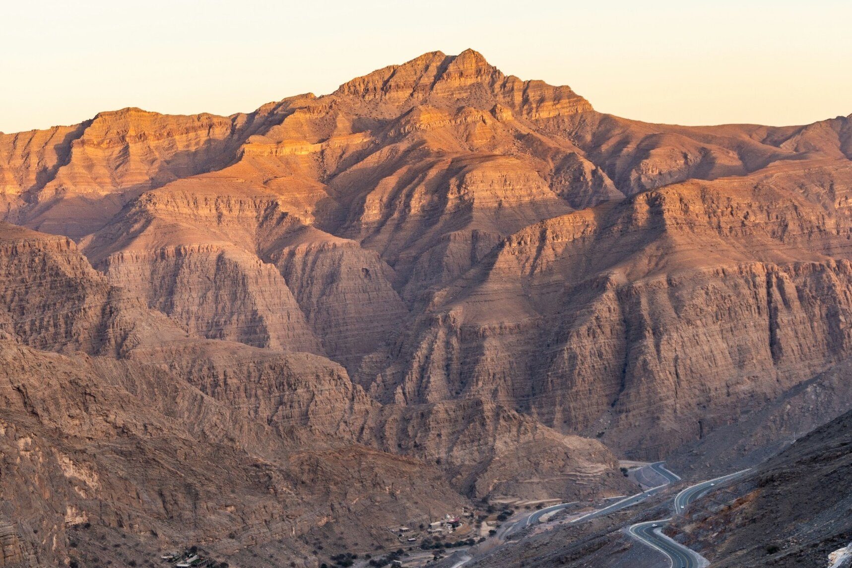 Jebel Jais en la hora dorada, con la carretera de montaña serpenteando hacia lo alto en Ras Al Khaimah